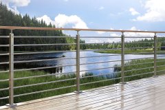 Lakeside view from a deck protected by horizontal bar railing